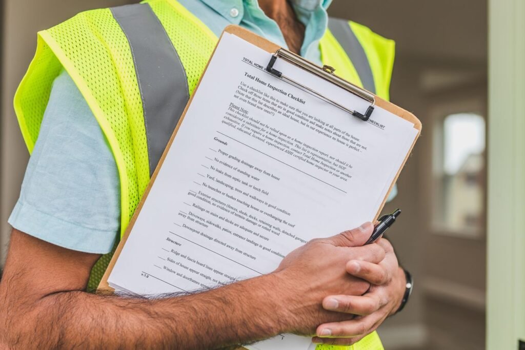 Inspector in a safety vest marking an inspection checklist on site