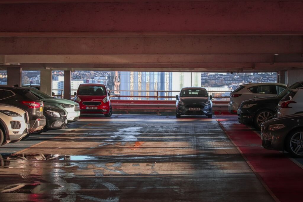 Cars parked on an open multi-level parking deck overlooking the city