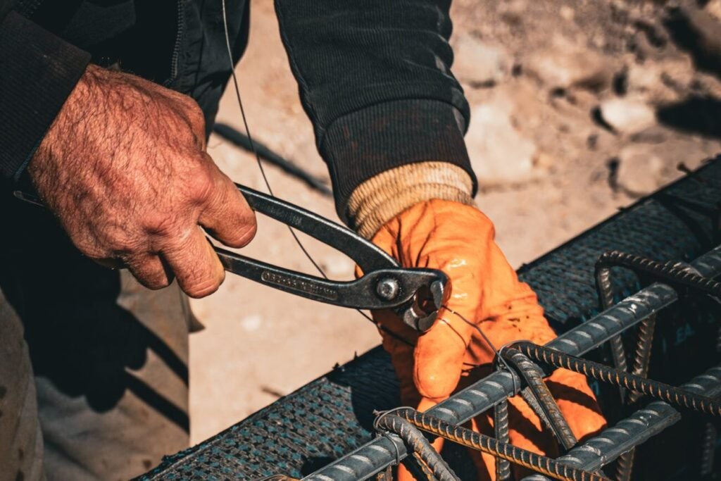 Construction worker tightening steel reinforcement with a wrench